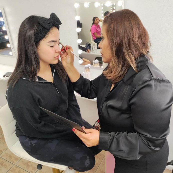 A woman is applying makeup to another woman 's face