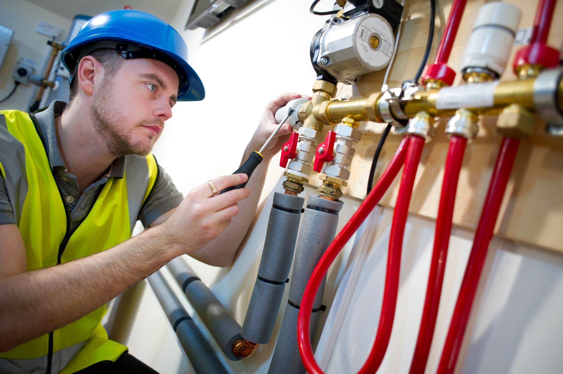 Professional engineer setting up underfloor heating pipes, showcasing skilled water heater repair.