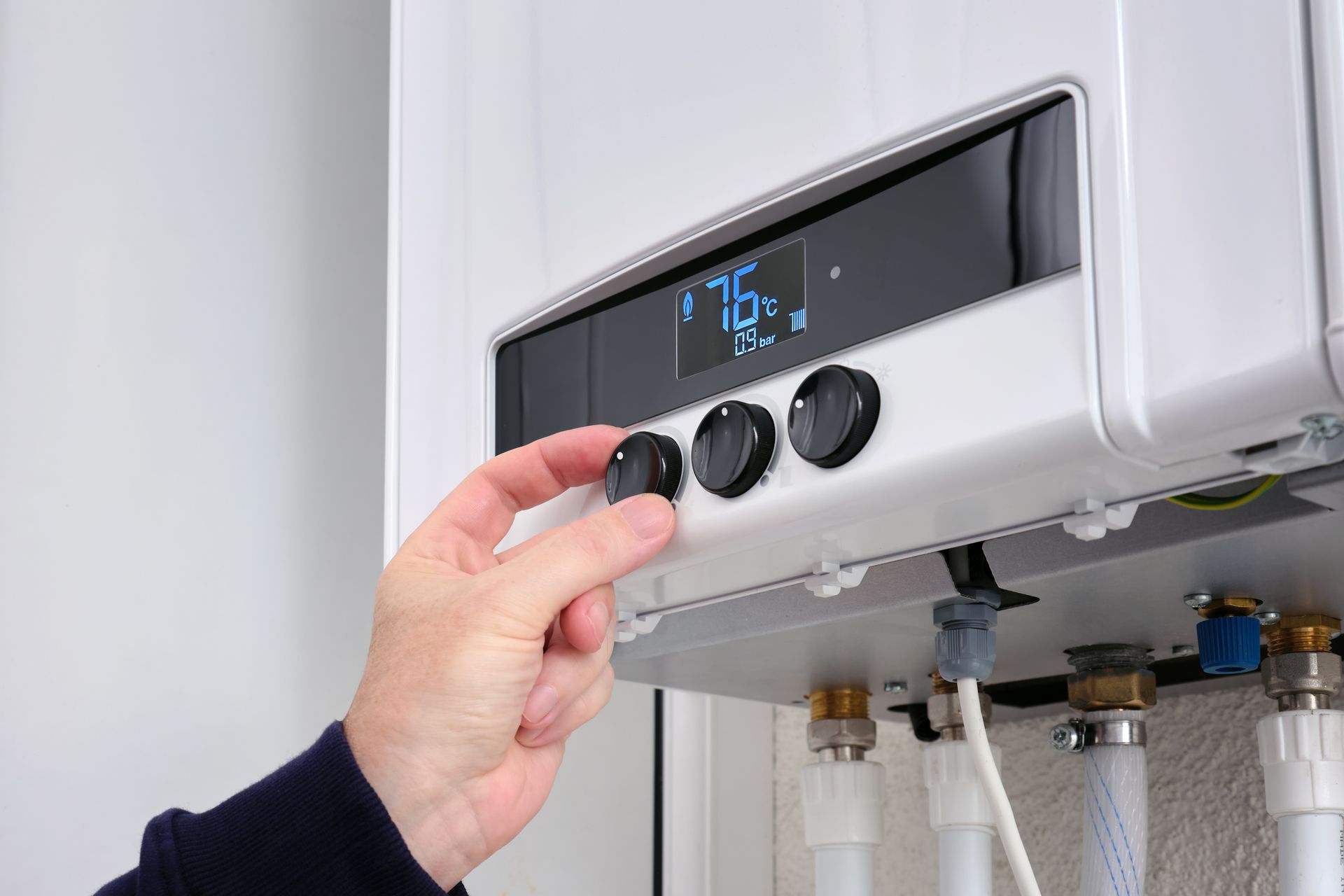 Close up of a man's hand changing the temperature on a water heater Close up of a man's hand changing the temperature on a water heater