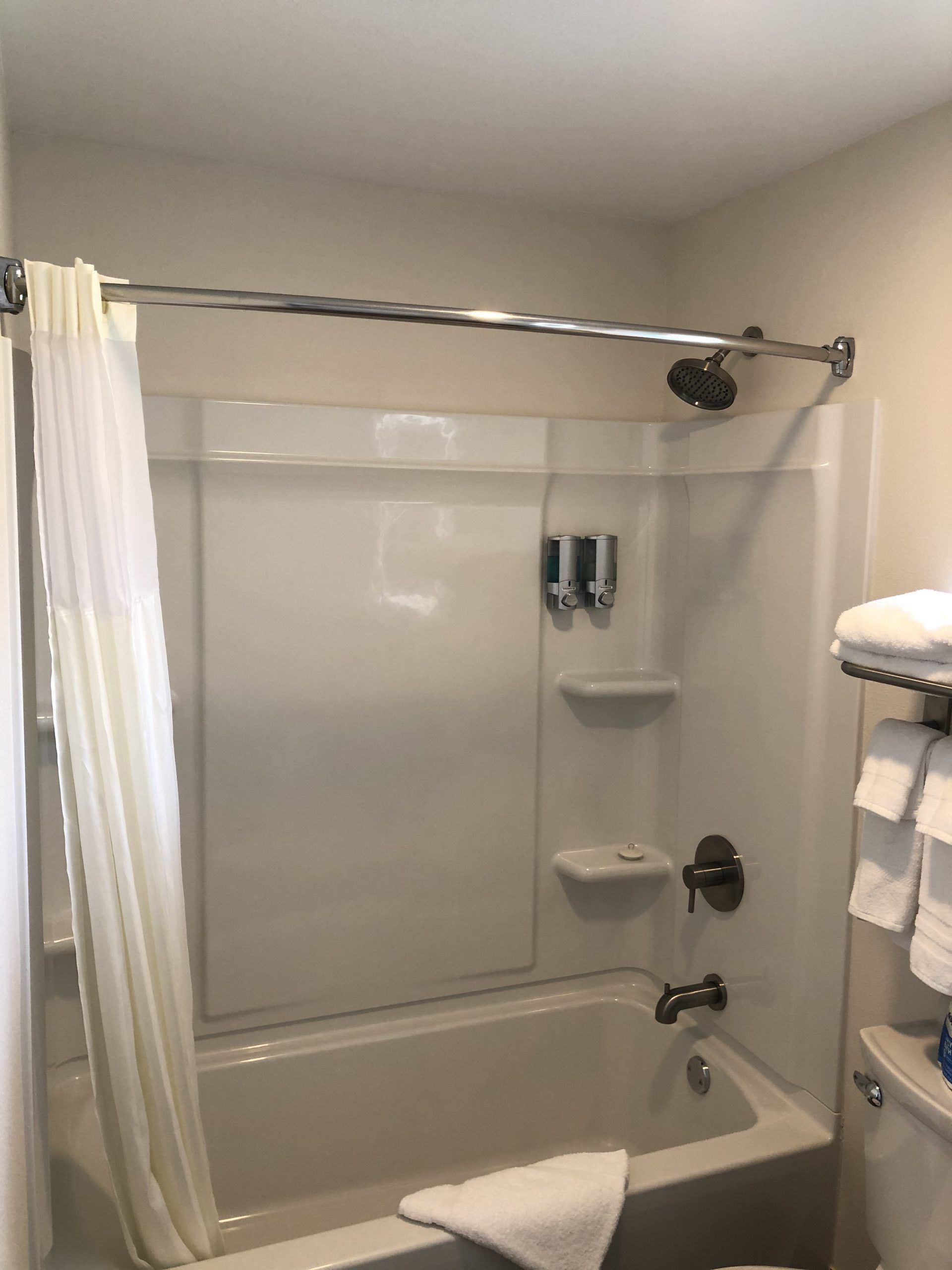 Bathroom with a white bathtub and shower with a curtain.