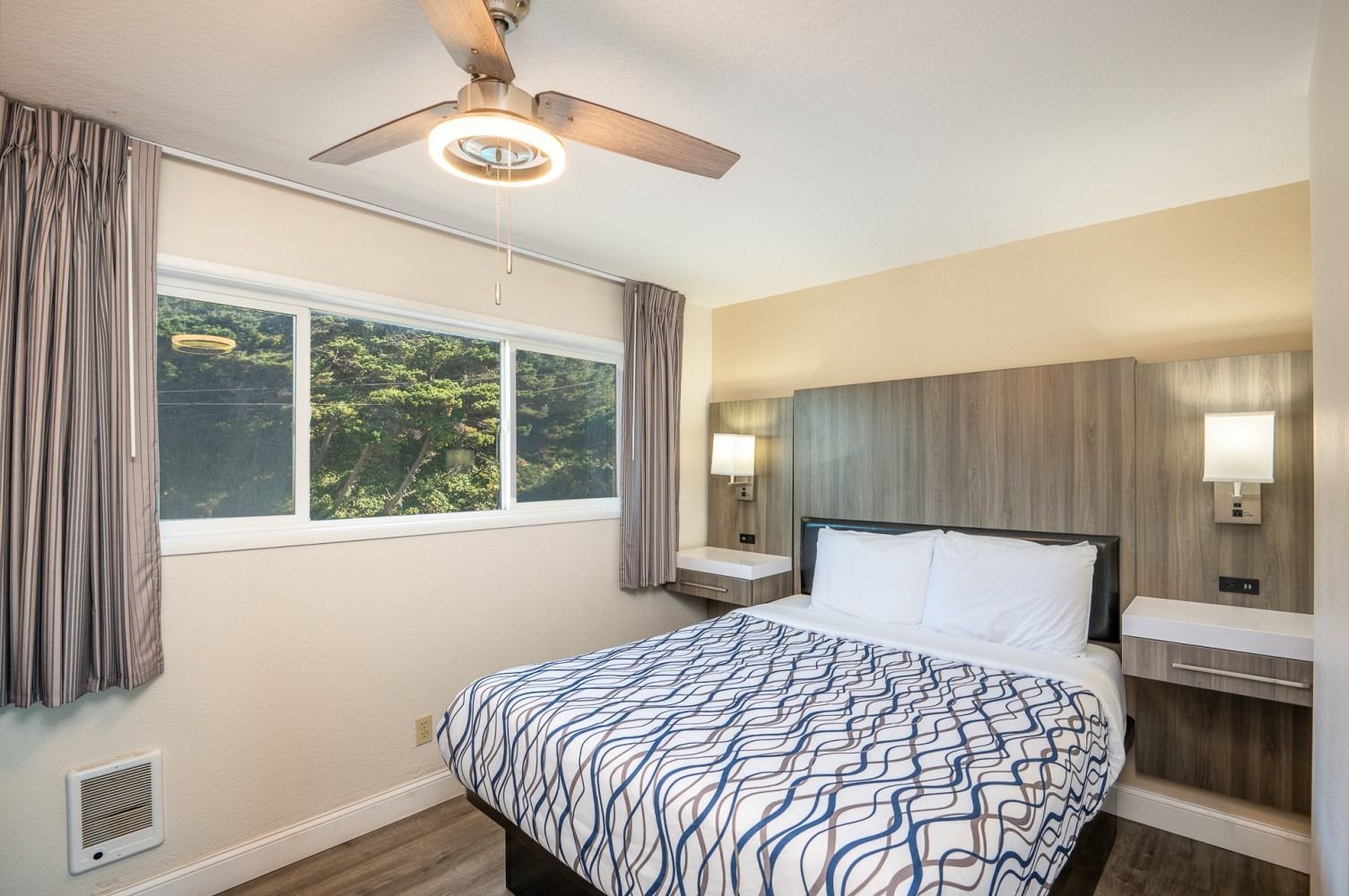 Bedroom with a double bed, a window, and a ceiling fan; neutral tones.