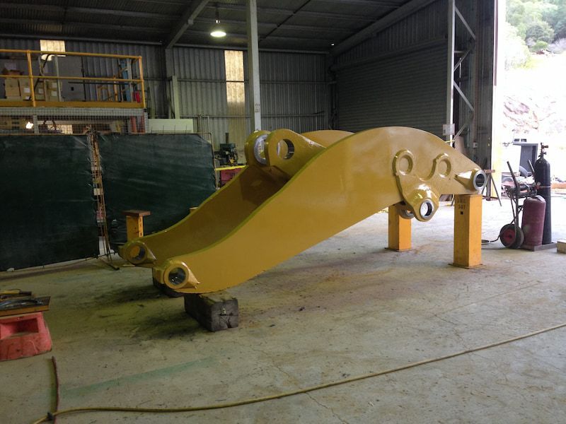 A large yellow piece of equipment is sitting in a warehouse — Line Boring in Chevallum, QLD