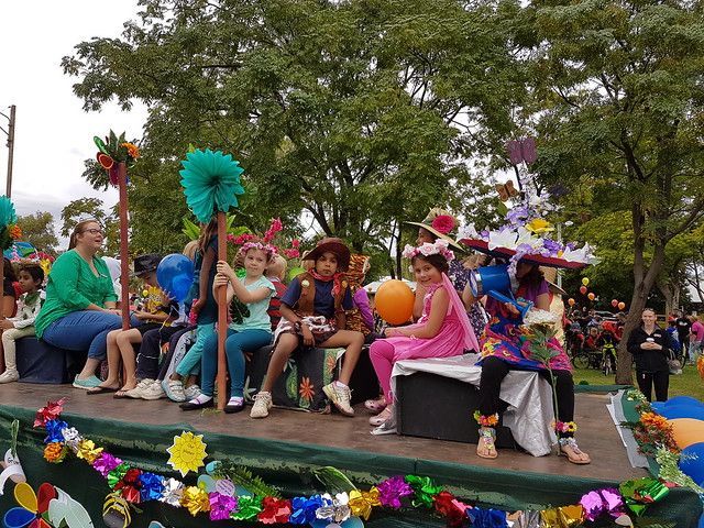 a group of children are sitting on a float in a parade .