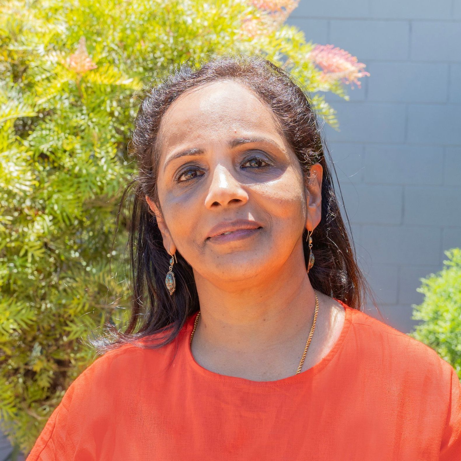 a woman in a green polka dot shirt is smiling for the camera .