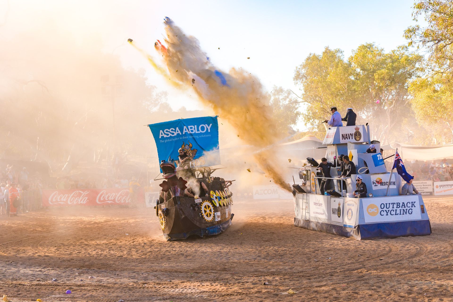 a couple of cars are racing on a dirt road .