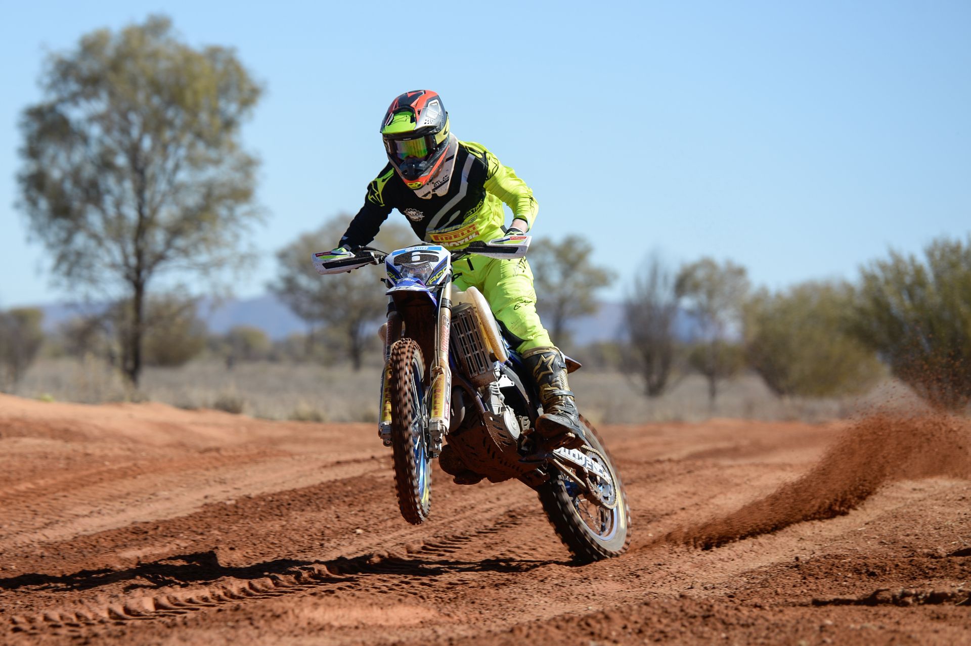 a man is riding a dirt bike on a dirt road .