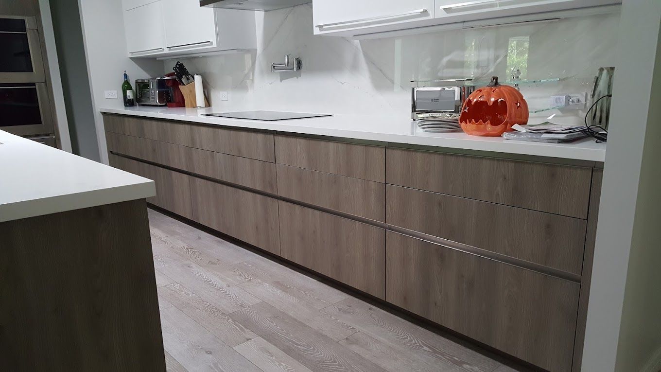 A kitchen with wooden cabinets and a pumpkin on the counter.