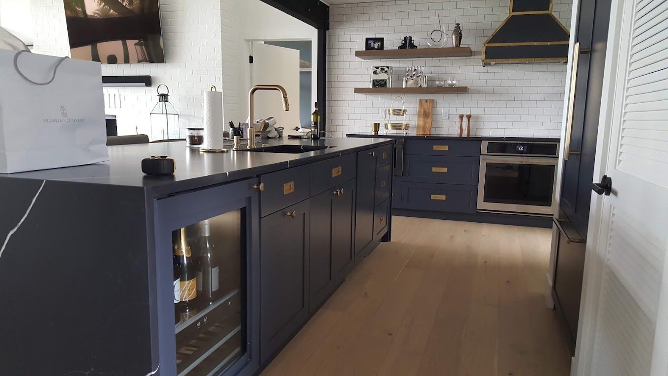 A kitchen with blue cabinets and a wine cooler