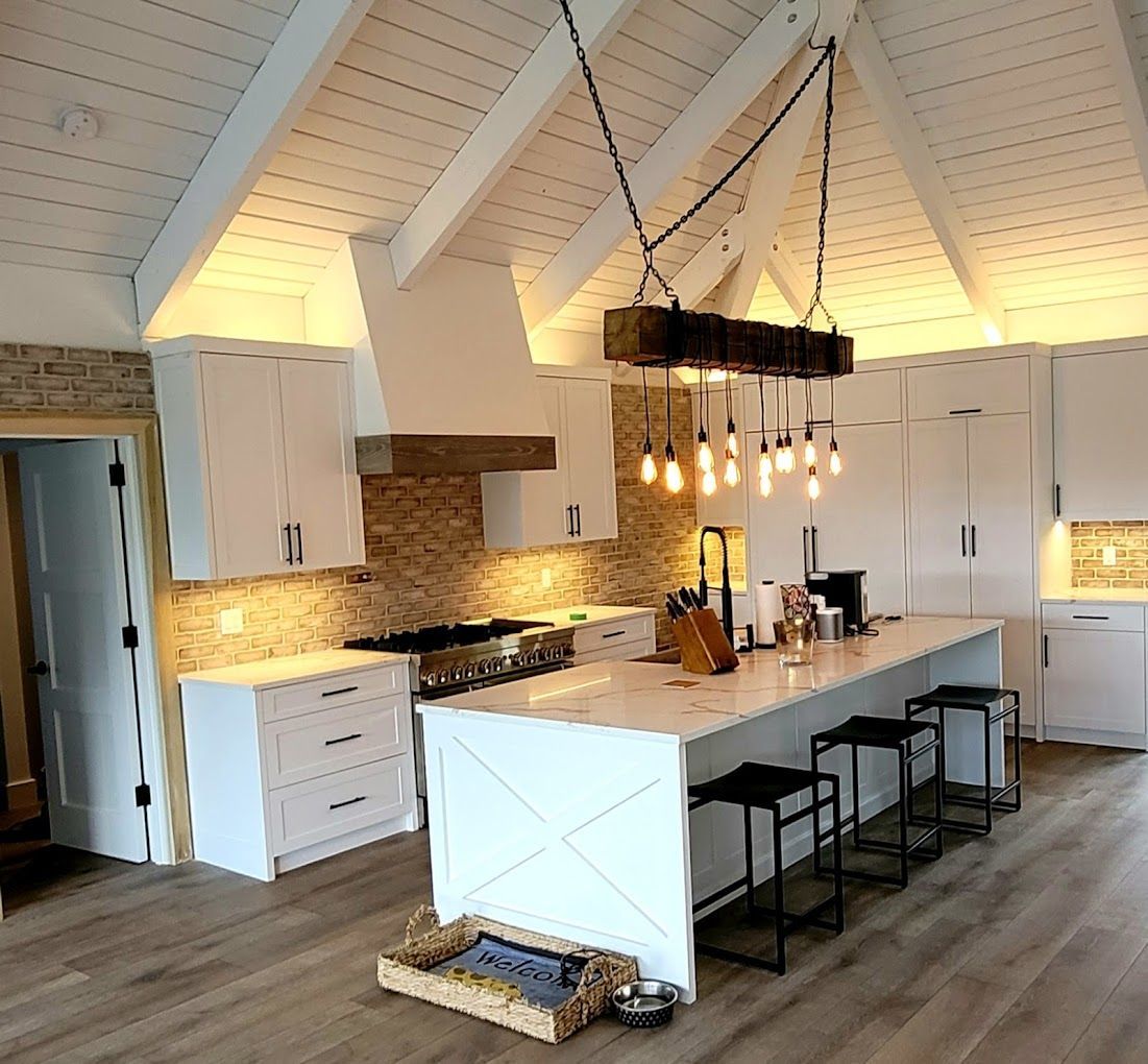 A kitchen with white cabinets and a large island