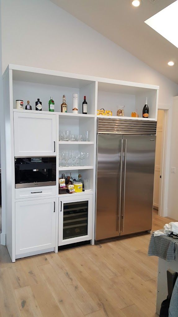 A kitchen with stainless steel appliances and white cabinets.