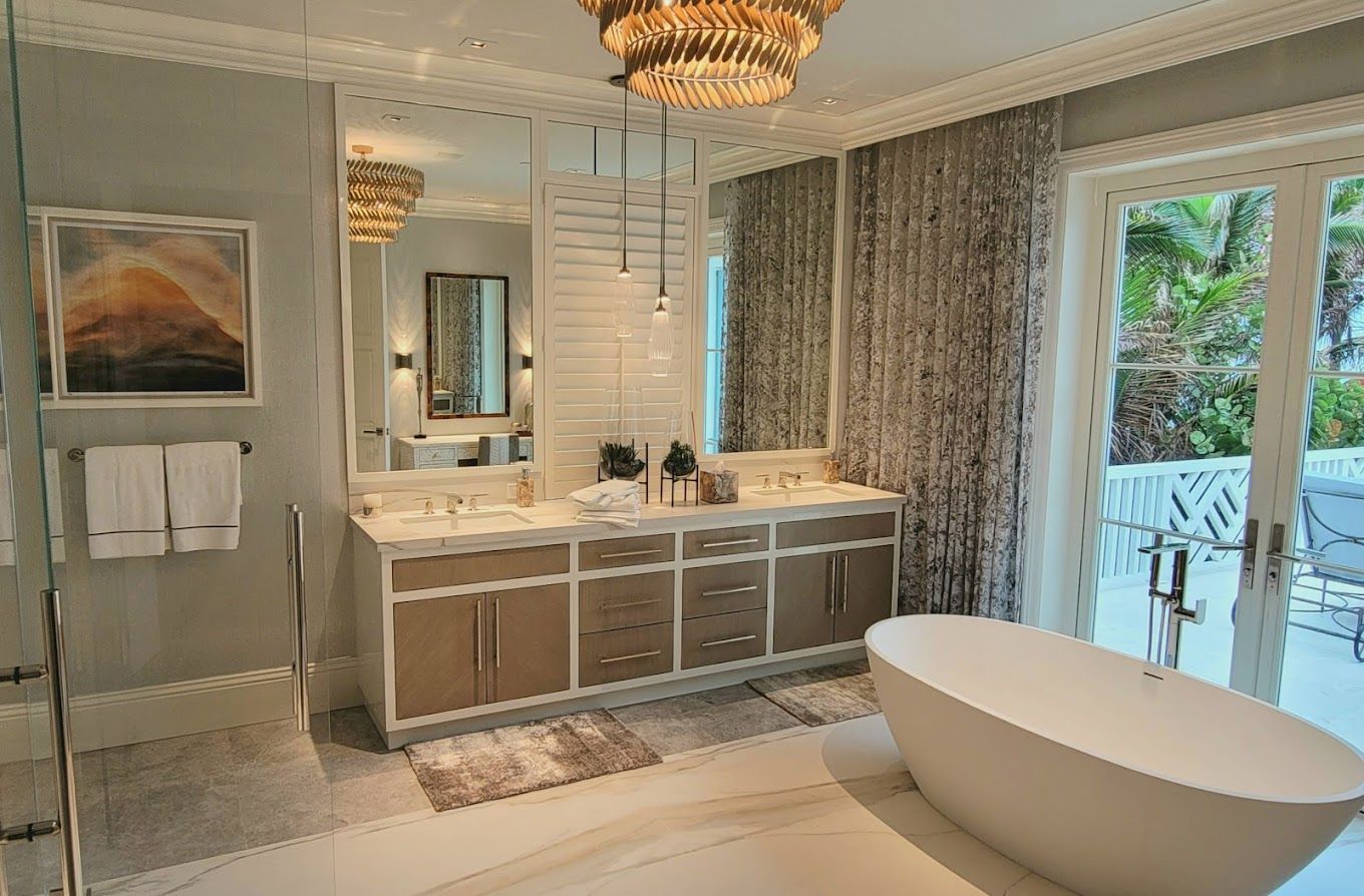 A bathroom with a tub , sinks , mirrors and a chandelier.