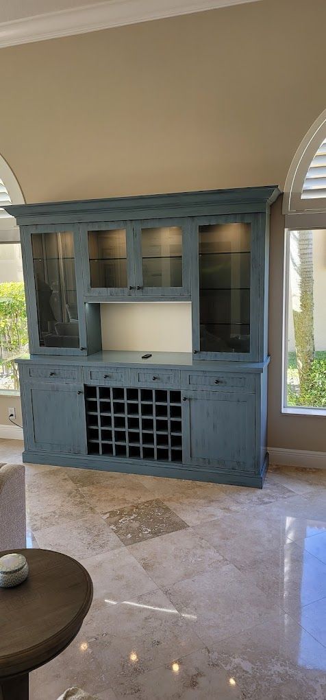 A living room with a blue cabinet and a wine rack.