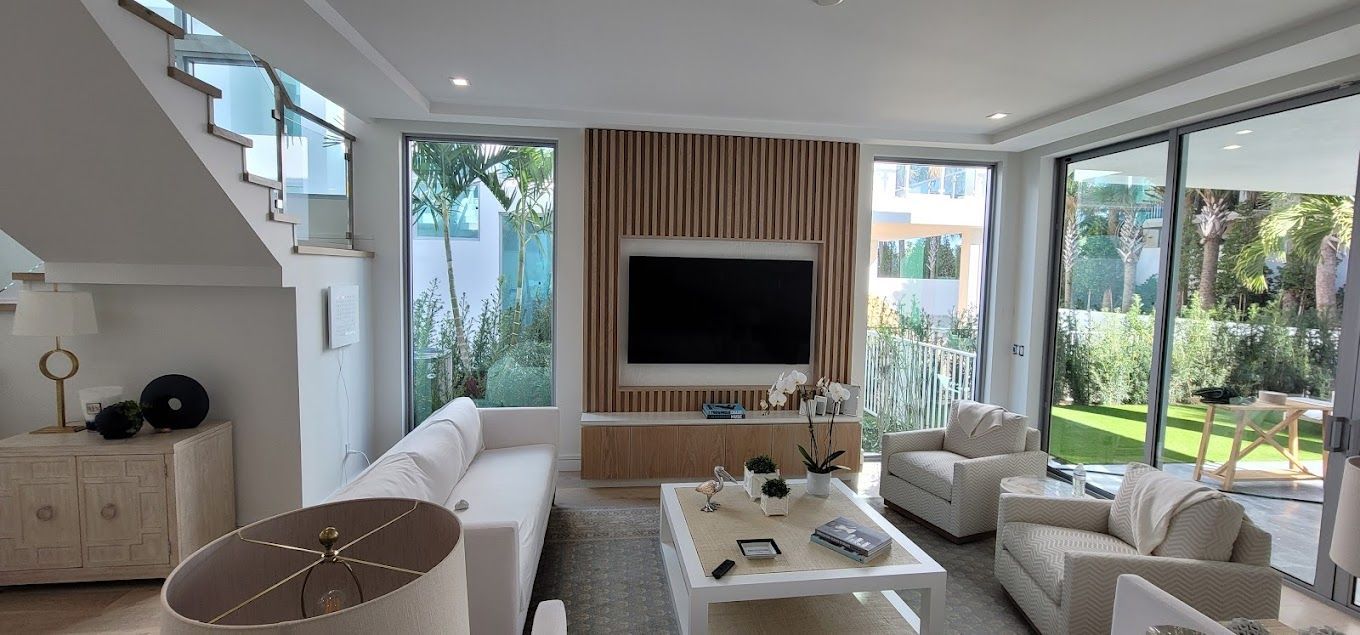 A living room with white furniture and a flat screen tv
