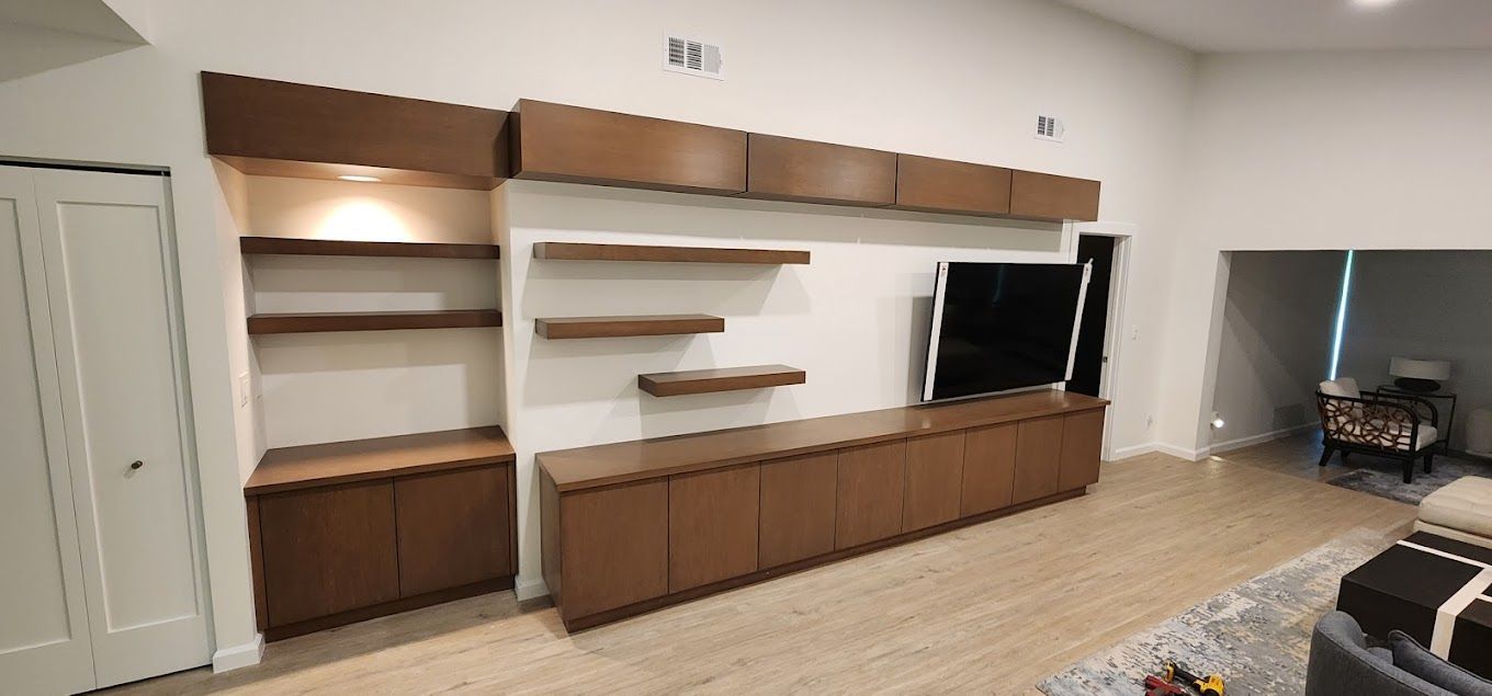 A living room with a large entertainment center and a flat screen tv.