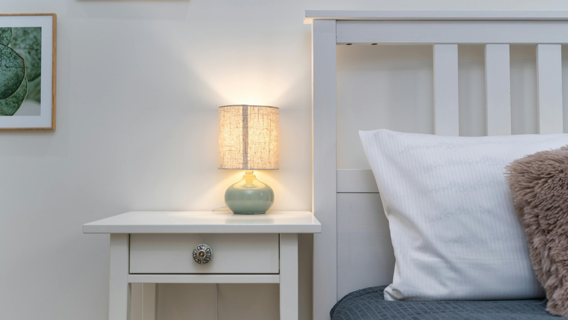 There is a lamp on the nightstand next to the bed.