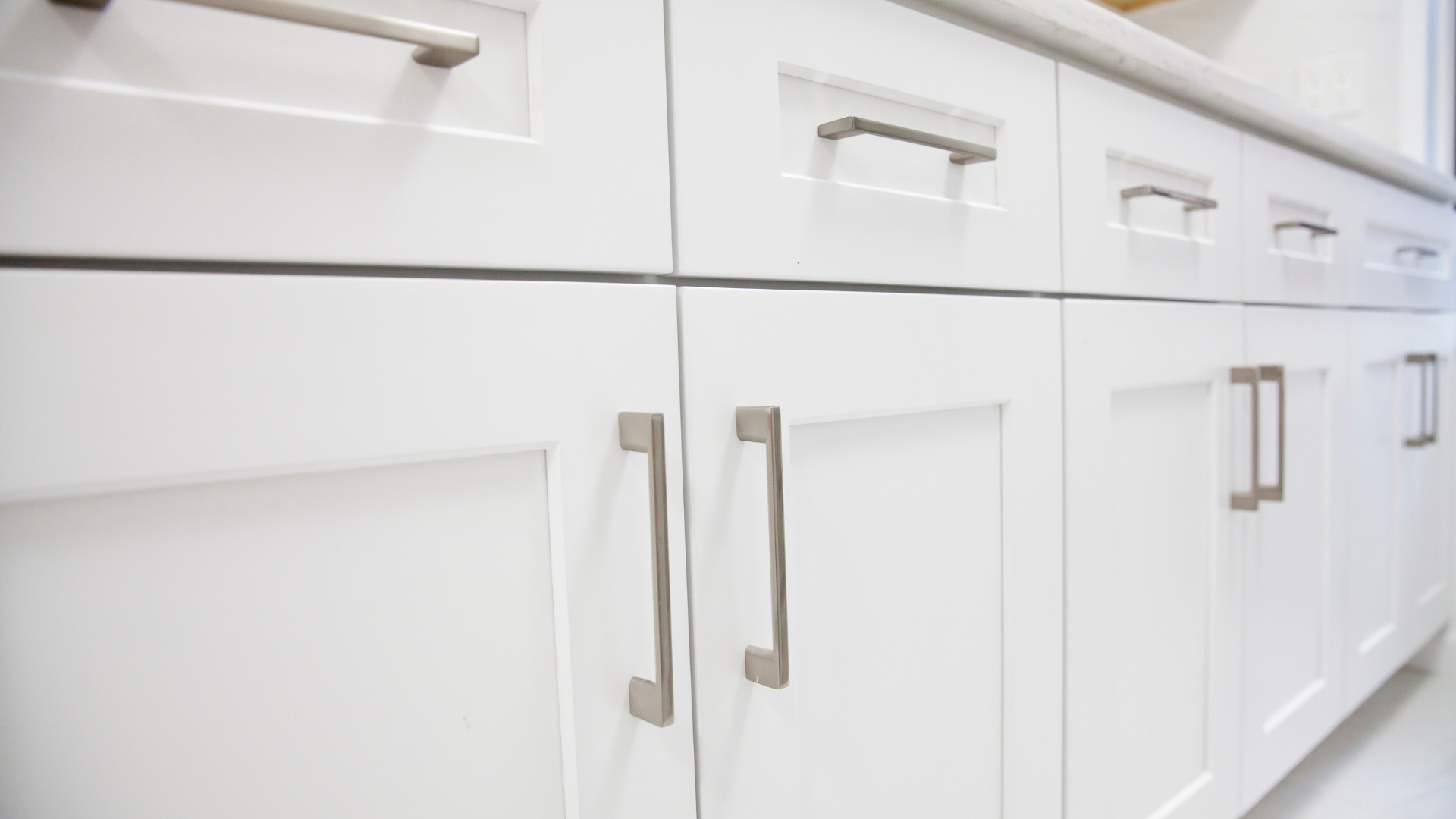 A close up of a kitchen cabinet with stainless steel handles.