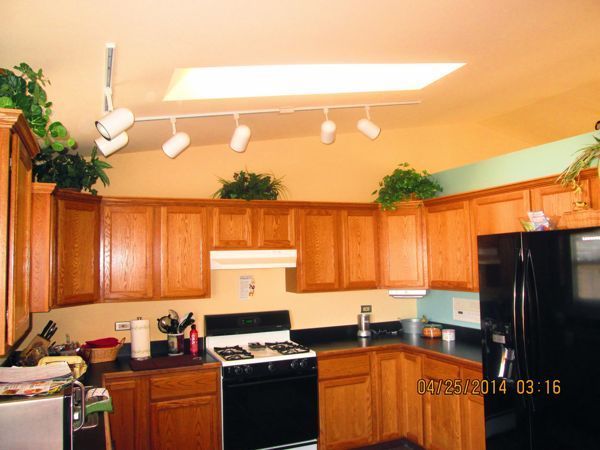 A kitchen with wooden cabinets and a black refrigerator