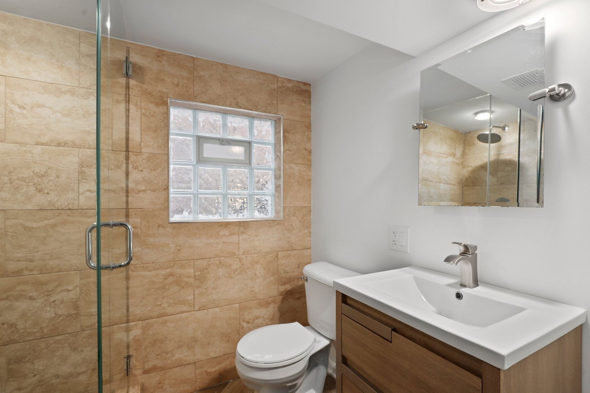 A bathroom with a toilet , sink , and shower.