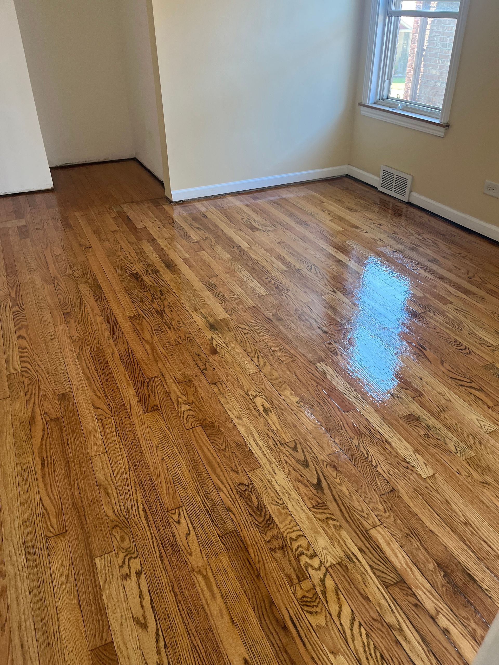 A living room with hardwood floors and a window.