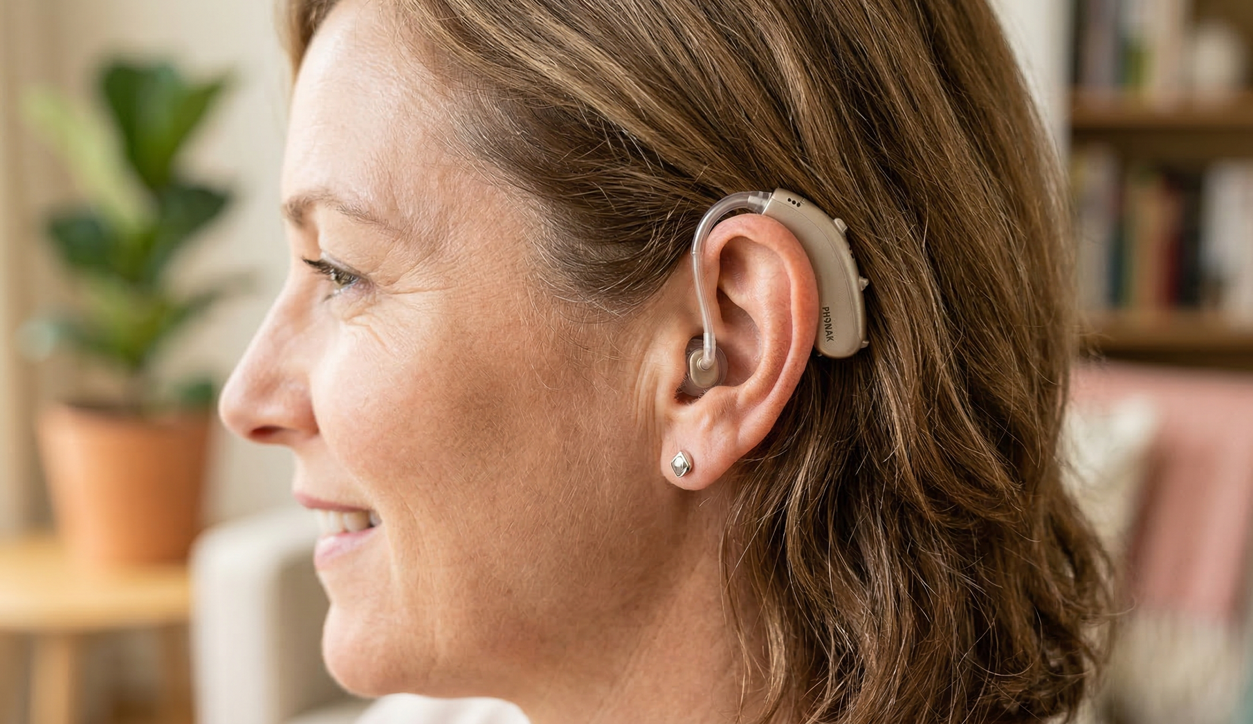A young boy wearing a hearing aid in his left ear.