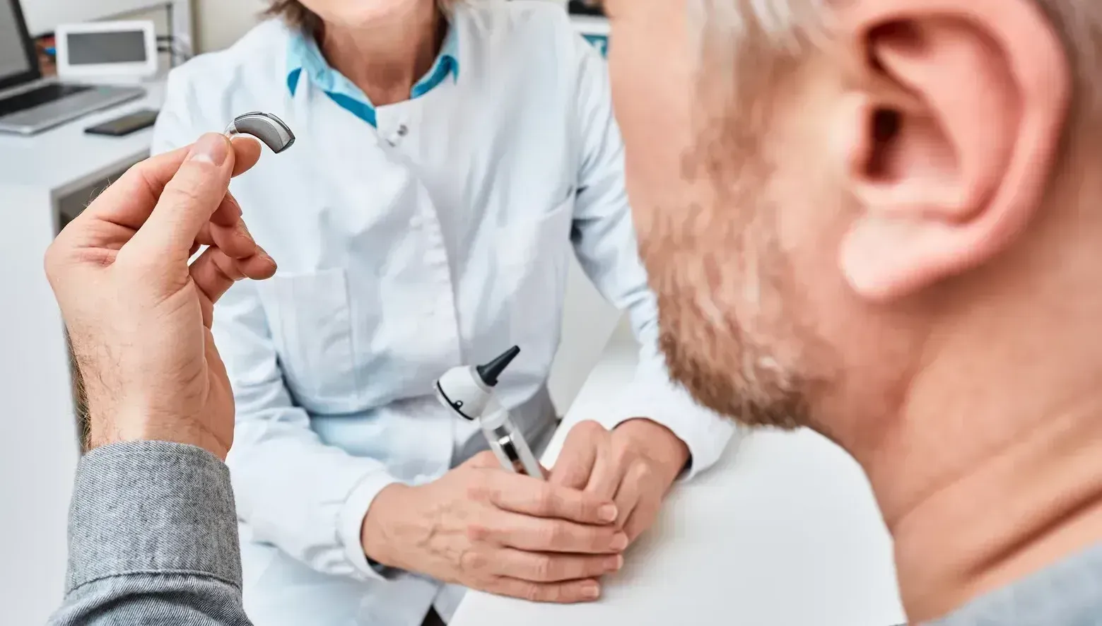 A man is getting a hearing aid from a doctor.