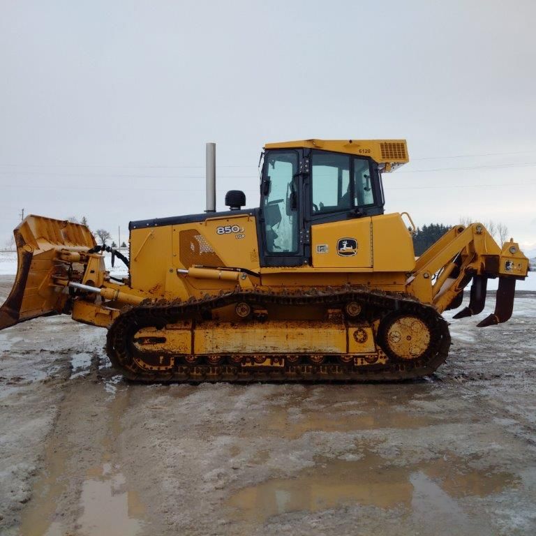 A yellow bulldozer is parked in a muddy field