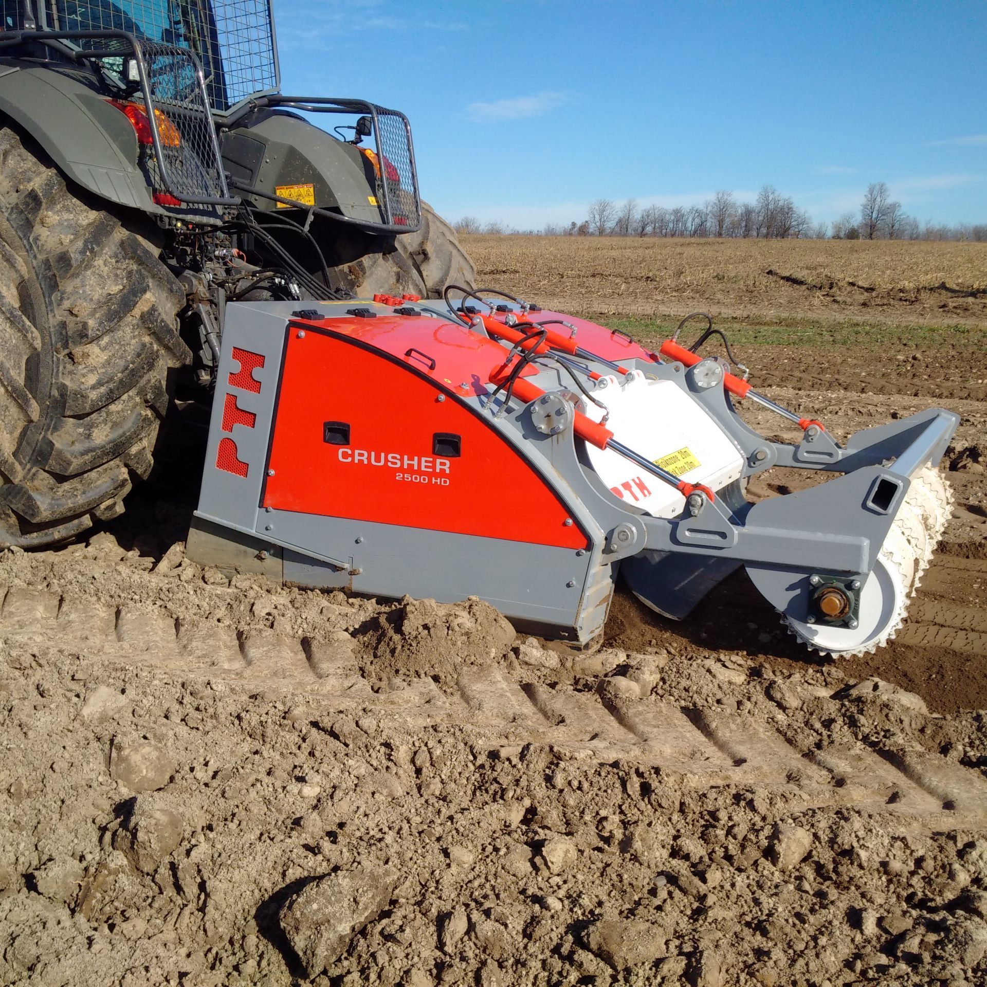 A tractor with a machine that says ptm on it