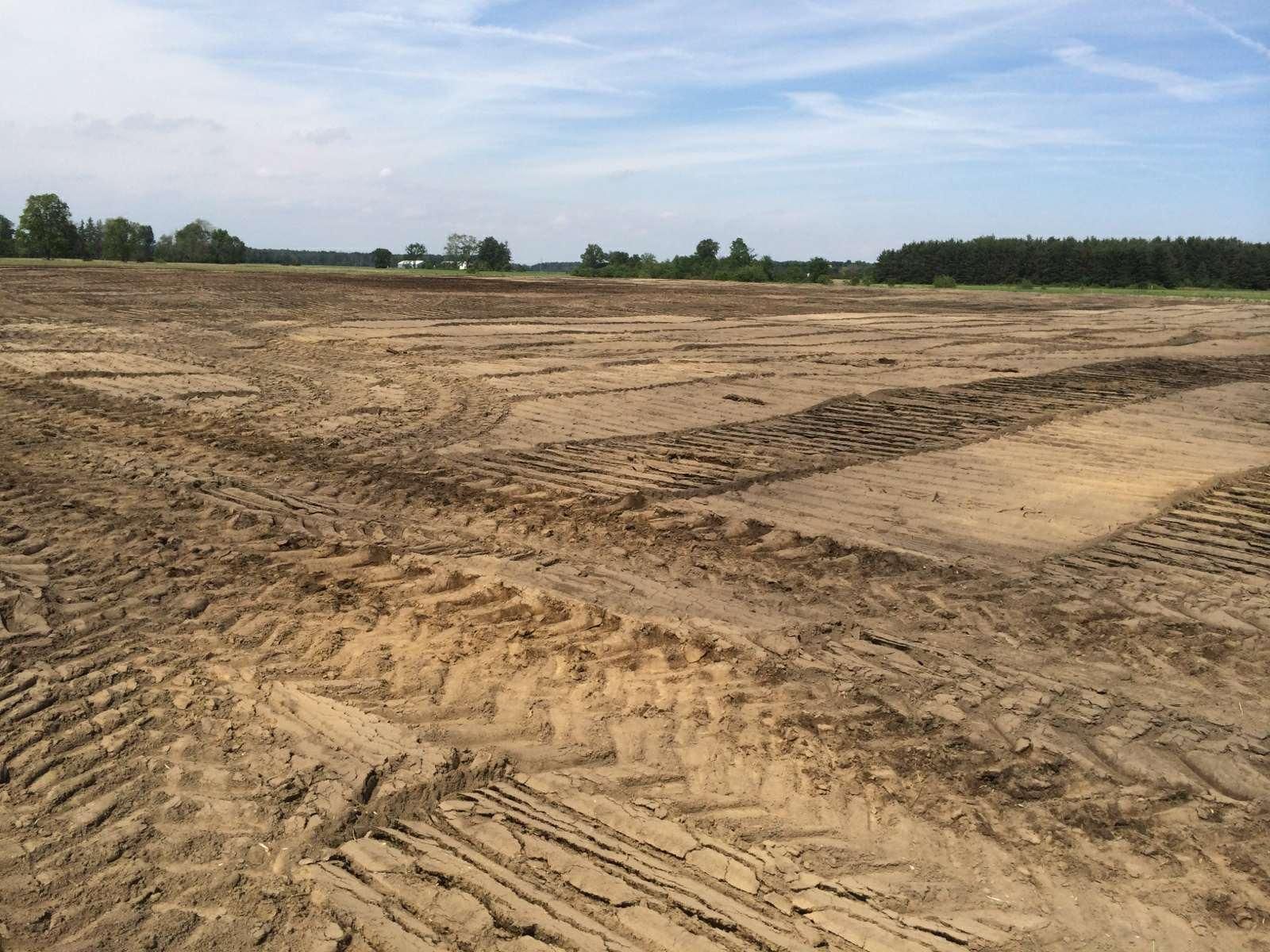 A large dirt field with a lot of tire tracks in it