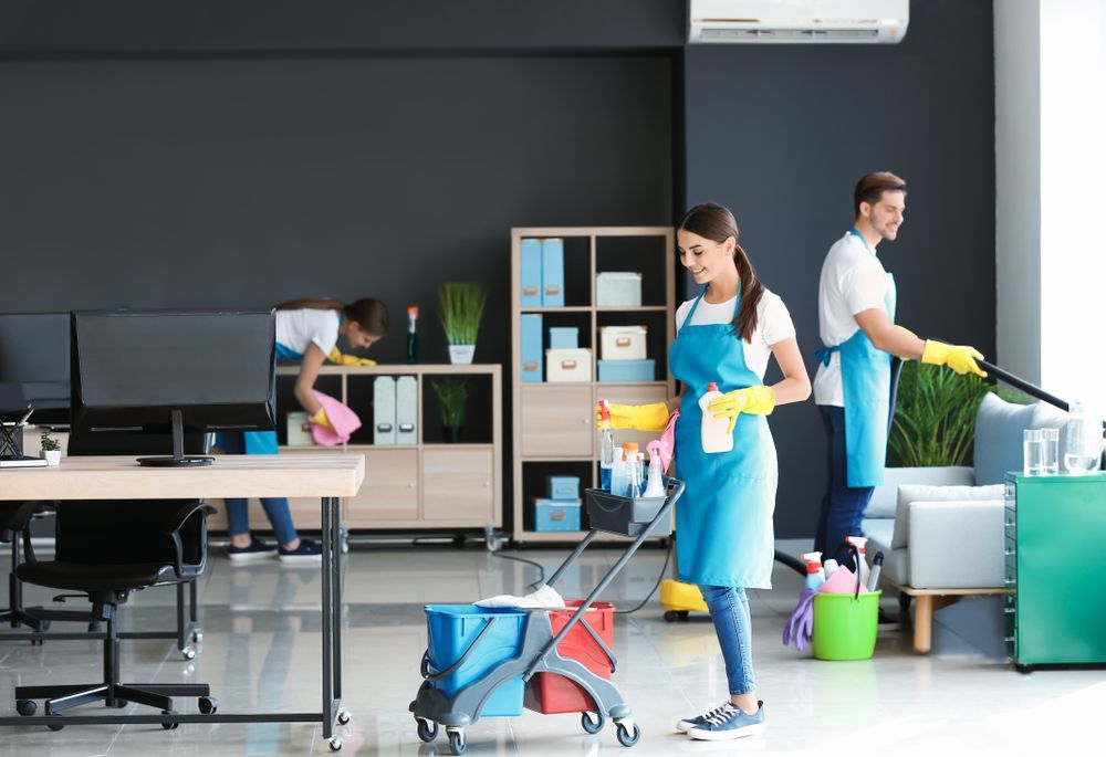 A man and a woman are cleaning an office.