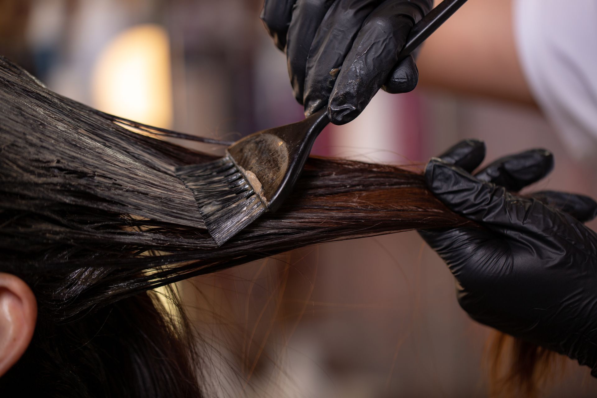 A woman is getting her hair dyed by a hairdresser.