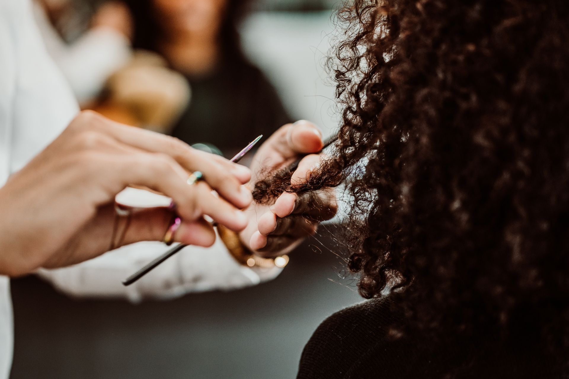 A woman is getting her hair cut by a hairdresser.