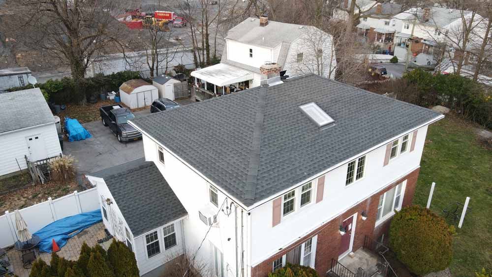 An aerial view of a house with a roof that has a skylight.