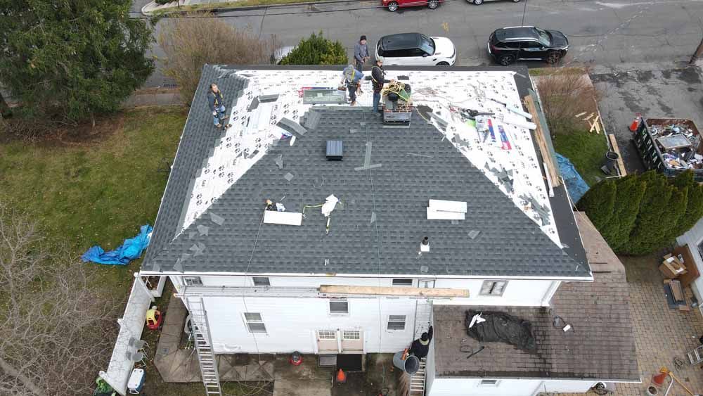 An aerial view of a house with a roof that is being repaired.