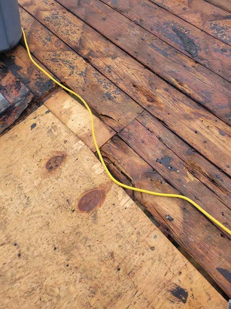 A yellow cord is connected to a wooden deck.