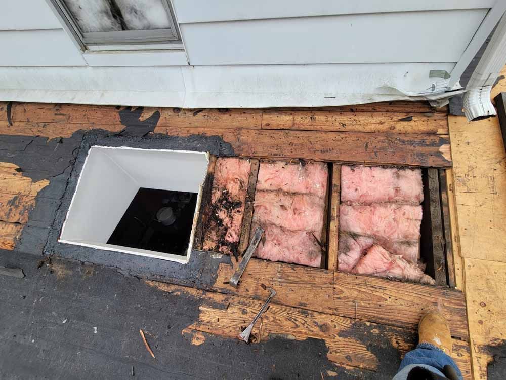 A hole in the roof of a house with a window.