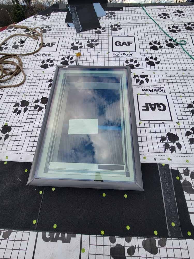 A skylight is sitting on top of a roof.