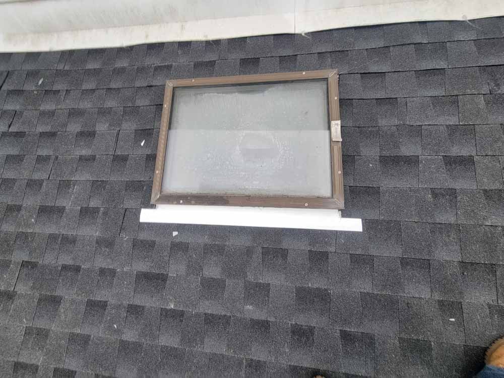 A roof with a skylight in the middle of it