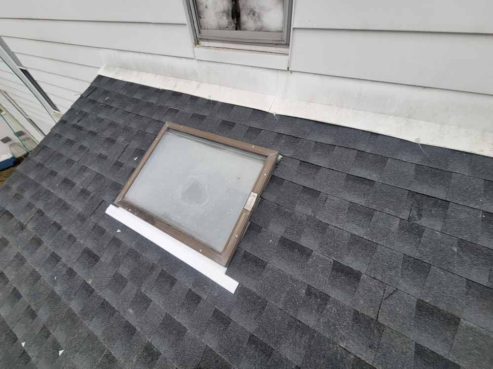 There is a skylight on the roof of a house.