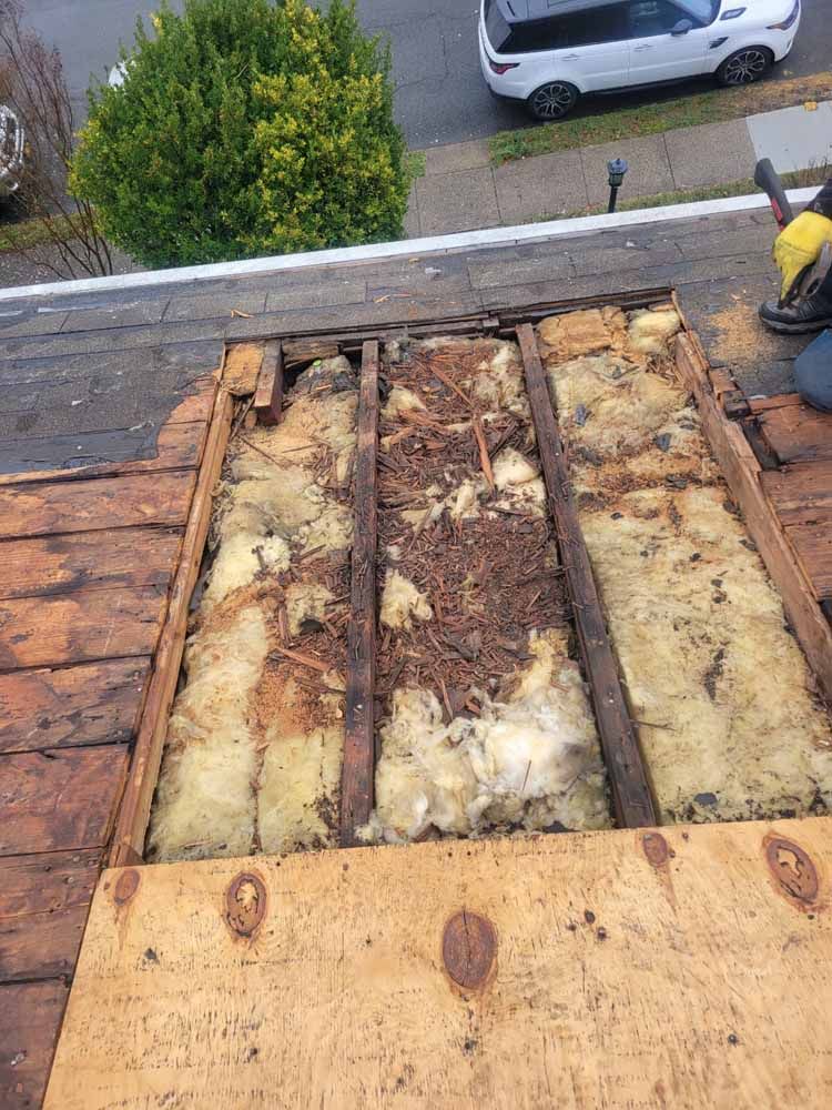 A person is working on a roof with a lot of wood and insulation.