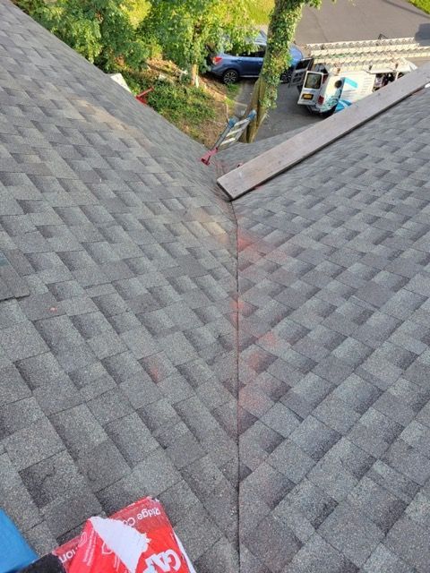 A roof with a bag of shingles on it