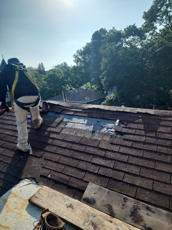 A man is working on the roof of a house.