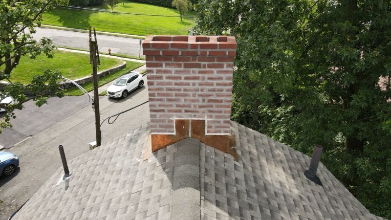 An aerial view of a brick chimney on top of a roof.