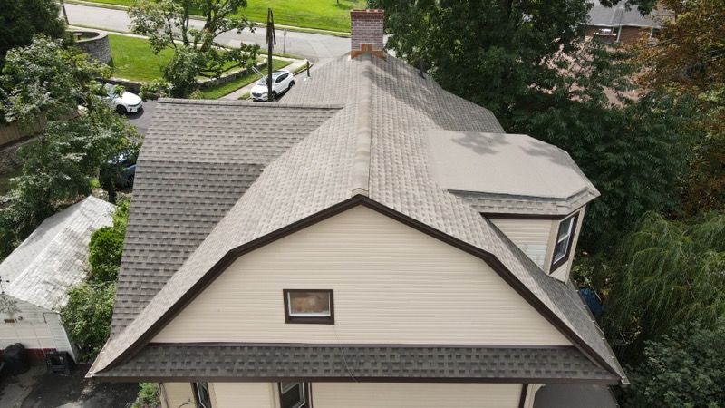 An aerial view of a house with a roof that has shingles on it.