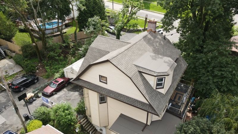 An aerial view of a house with a gray roof