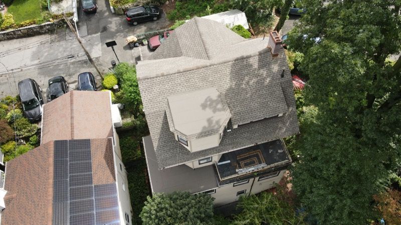 An aerial view of a house with solar panels on the roof.