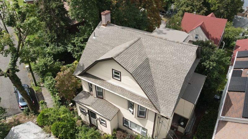 An aerial view of a house with a gray roof