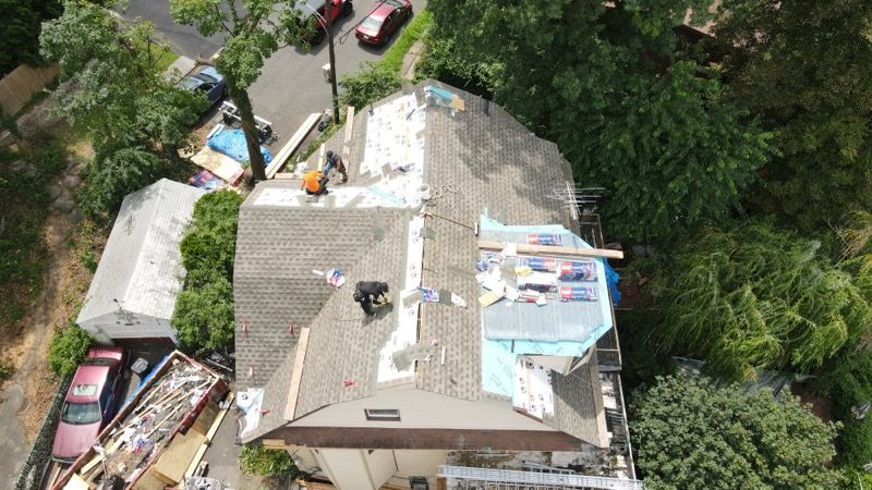 An aerial view of a house with a roof being repaired.