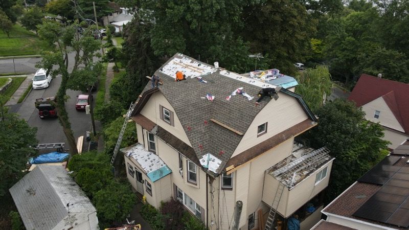 An aerial view of a house with a roof that is being repaired.