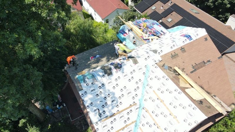 A group of people are working on the roof of a house.