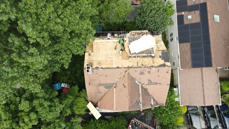 An aerial view of a house with a roof being repaired.